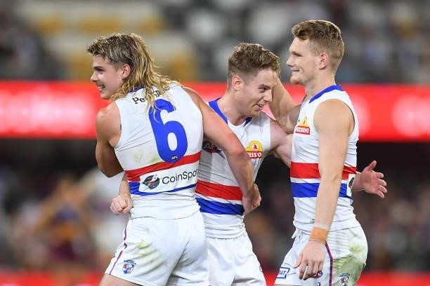 Western Bulldogs players Bailey Smith, Lachie Hunter and Adam Treloar celebrate victory during the AFL 1st Semi Final match between the Brisbane...
