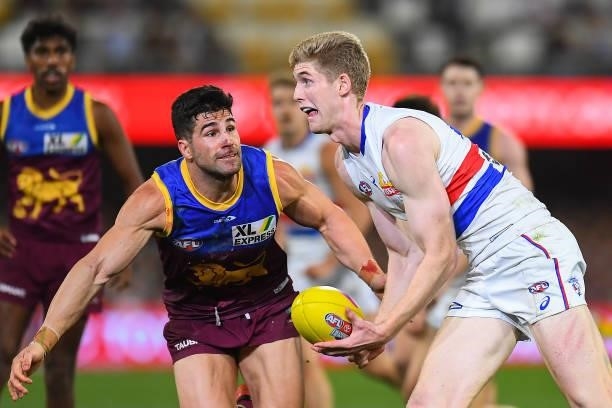 Tim English of the Bulldogs controls the ball under pressure from Marcus Adams of the Lions during the AFL 1st Semi Final match between the Brisbane...