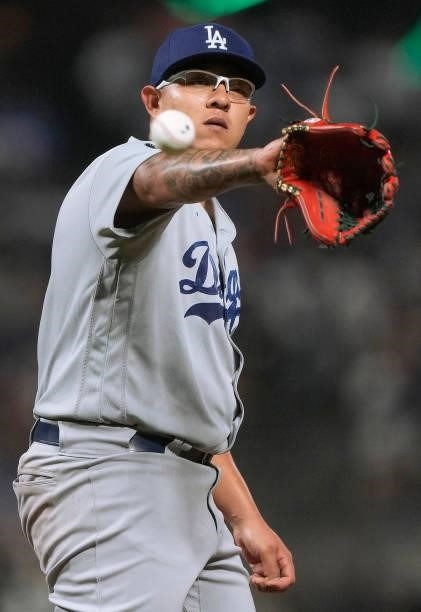 Julio Urias of the Los Angeles Dodgers catches a new baseball thrown into the game against the San Francisco Giants in the bottom of the six inning...