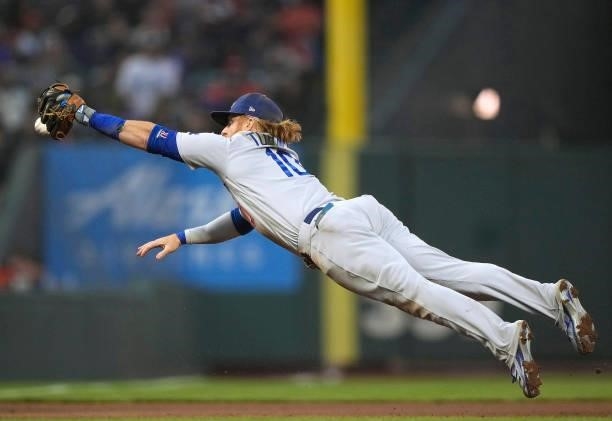 Justin Turner of the Los Angeles Dodgers dives for the ball that gets past him for a double off the bat of Mauricio Dubon of the San Francisco Giants...