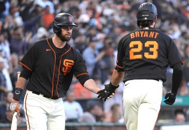Kris Bryant of the San Francisco Giants is congratulated by Brandon Belt after Bryant scored against the Los Angeles Dodgers in the bottom of the...