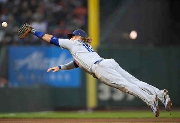 Justin Turner of the Los Angeles Dodgers dives for the ball that gets past him for a double off the bat of Mauricio Dubon of the San Francisco Giants...