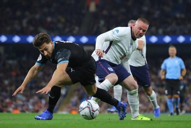 Kem Cetinay of Soccer Aid World XI is tackled by Wayne Rooney of England during the Soccer Aid for Unicef 2021 match between England and Soccer Aid...