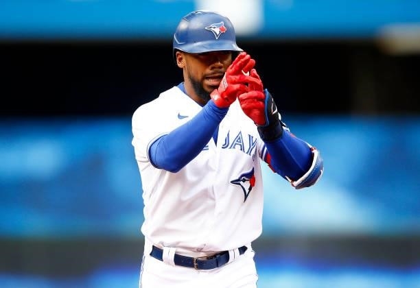 Teoscar Hernandez of the Toronto Blue Jays signals to the dugout after hitting his 100th career home run during a MLB game against the Oakland...