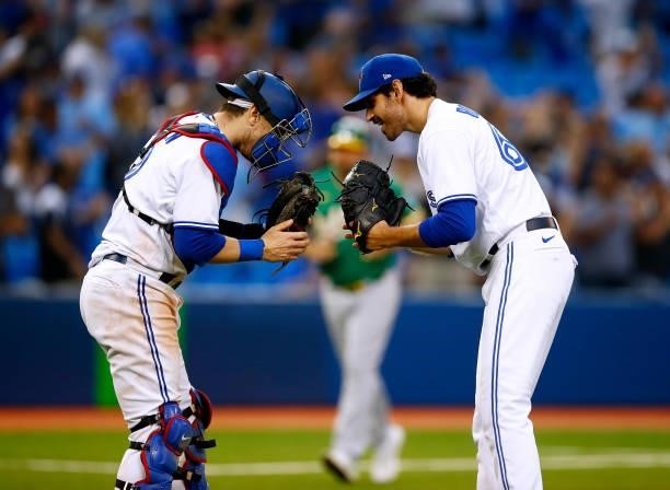 Jordan Romano of the Toronto Blue Jays celebrates the win with catcher Danny Jansen following a MLB game against the Oakland Athletics at Rogers...