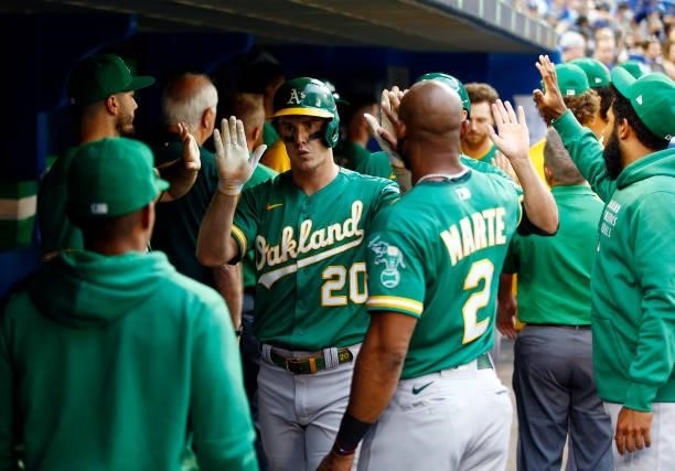Mark Canha of the Oakland Athletics celebrates with teammates after hitting a 3 run home run in the ninth inning during a MLB game against the...