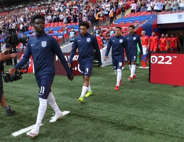 Bukayo Saka, Trent Alexander-Arnold of England and teammates walk onto the pitch prior to the 2022 FIFA World Cup Qualifier match between England and...