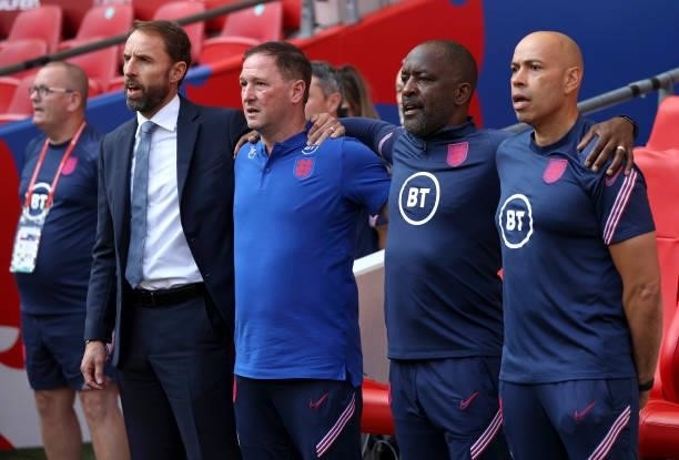 Gareth Southgate, Head Coach of England, Steve Holland, Chris Powell and Paul Nevin sing the national anthem prior to the 2022 FIFA World Cup...