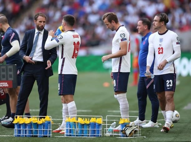 Gareth Southgate, Head Coach of England talks to Mason Mount, Harry Kane and Jack Grealish of England as they prepare to be substituted on during the...