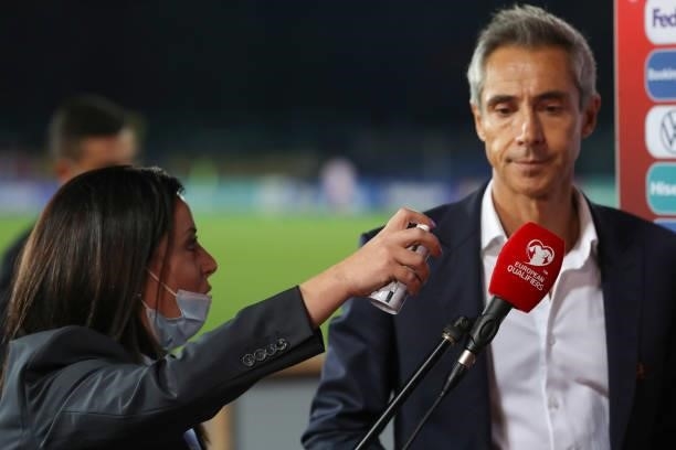 Member of staff sanitizes a microphone beofre Paulo Sousa Head coach of Poland is interviewed following the final whistle of the 2022 FIFA World Cup...