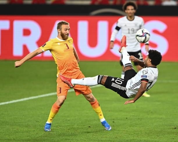 Serge Gnabry of Germany is tackled by Varazdat Haroyan of Armenia during the 2022 FIFA World Cup Qualifier match between Germany and Armenia at...