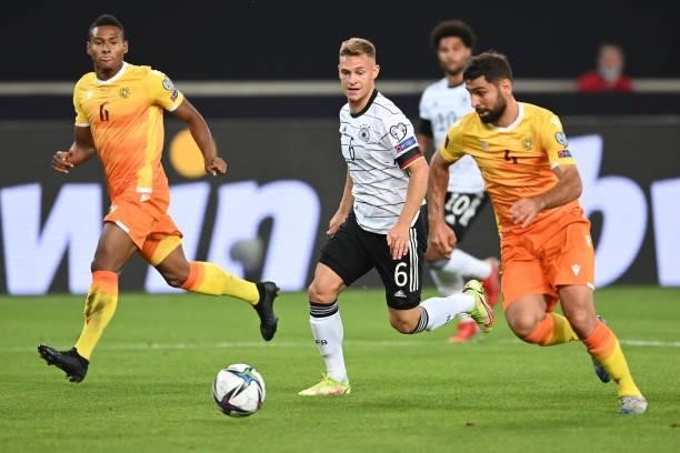 Joshua Kimmich of Germany is tackled by Taron Voskanyan and Wbeymar Angulo of Armenia during the 2022 FIFA World Cup Qualifier match between Germany...