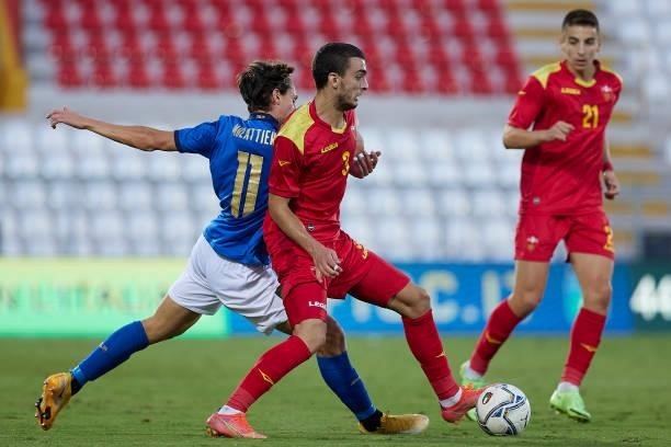 Samuele Mulattieri of Italy competes for the ball with Andrija Raznatovic of Montenegro during the UEFA European Under-21 Championship Qualifier...