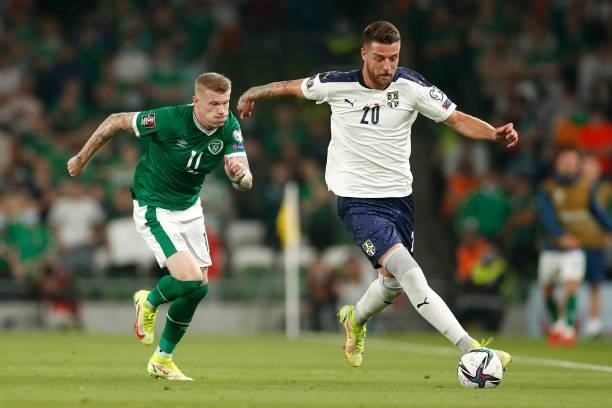 Sergej Milinkovic-Savic of Serbia runs with the ball whilst under pressure from James McClean of Republic of Ireland during the 2022 FIFA World Cup...