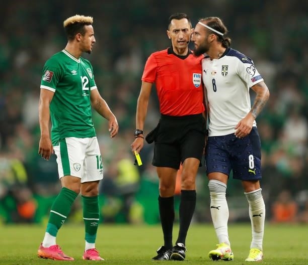 Nemanja Gudelj of Serbia clashes with Callum Robinson of Republic of Ireland as Match Referee, Jose María Sanchez intervenes during the 2022 FIFA...