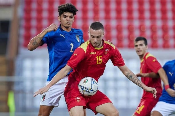 Vuk Strikovic of Montenegro competes for the ball with Raoul Bellanova of Italy during the UEFA European Under-21 Championship Qualifier between...