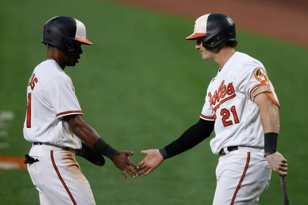 Cedric Mullins of the Baltimore Orioles celebrates with Austin Hays after scoring a first inning run against the Kansas City Royals at Oriole Park at...