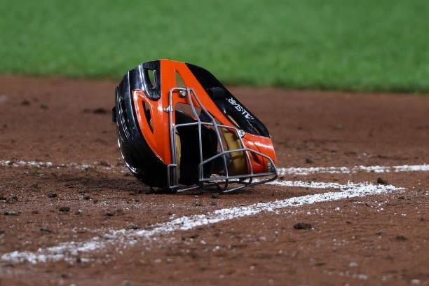 The helmet and mask of catcher Pedro Severino of the Baltimore Orioles sits on the ground during the third inning against the Kansas City Royals at...