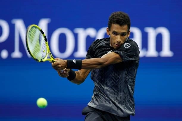 Felix Auger-Aliassime of Canada returns the ball against Carlos Alcaraz of Spain during his Men’s Singles quarterfinals match on Day Nine of the 2021...
