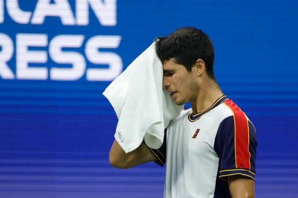 Carlos Alcaraz of Spain dries his face as he plays against Felix Auger-Aliassime of Canada during his Men’s Singles quarterfinals match on Day Nine...