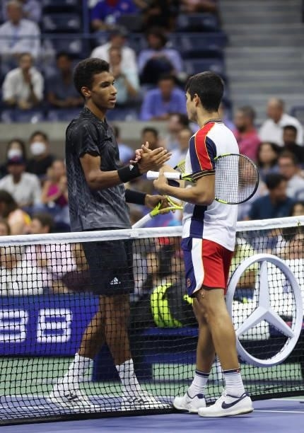 Felix Auger-Aliassime of Canada and Carlos Alcaraz of Spain meet at center court after Alcaraz retired during their Men’s Singles quarterfinals match...