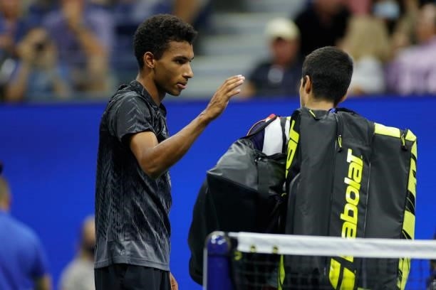 Felix Auger-Aliassime of Canada and Carlos Alcaraz of Spain meet at center court after Alcaraz retired early during their Men’s Singles quarterfinals...