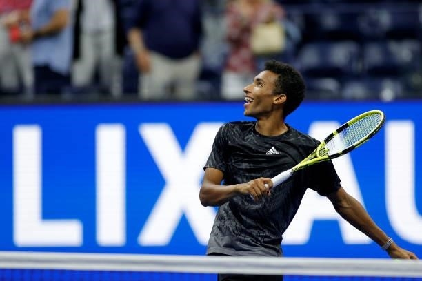Felix Auger-Aliassime of Canada hits tennis balls to the crowd after winning against Carlos Alcaraz of Spain due to Alcaraz retiring early in the...