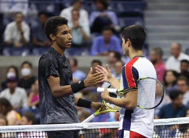 Felix Auger-Aliassime of Canada and Carlos Alcaraz of Spain meet at center court after Alcaraz retired early during the second set of their Men’s...
