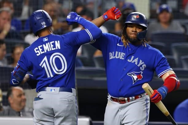Marcus Semien of the Toronto Blue Jays is congratulated by Vladimir Guerrero Jr. #27 after hitting a home run against the New York Yankees during the...