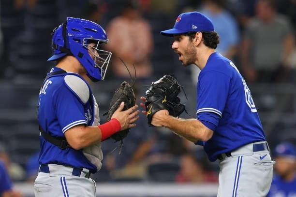 Catcher Reese McGuire and closer Jordan Romano of the Toronto Blue Jays bow to each after the final out as the defeated the New York Yankees 5-1 in a...