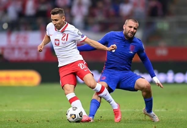 Przemyslaw Frankowski of Poland is challenged by Luke Shaw of England during the 2022 FIFA World Cup Qualifier match between Poland and England at...