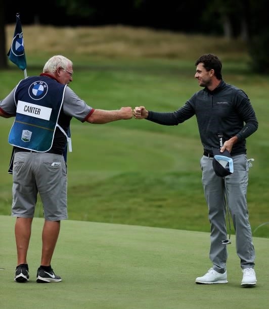 Laurie Canter of England fist bumps his caddie, after finishing his round on the 18th hole during Day One of The BMW PGA Championship at Wentworth...