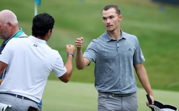 Nicolai Hojgaard of Denmark fist bumps Adrian Otaegui of Spain, after they finish their round on the 18th hole during Day One of The BMW PGA...