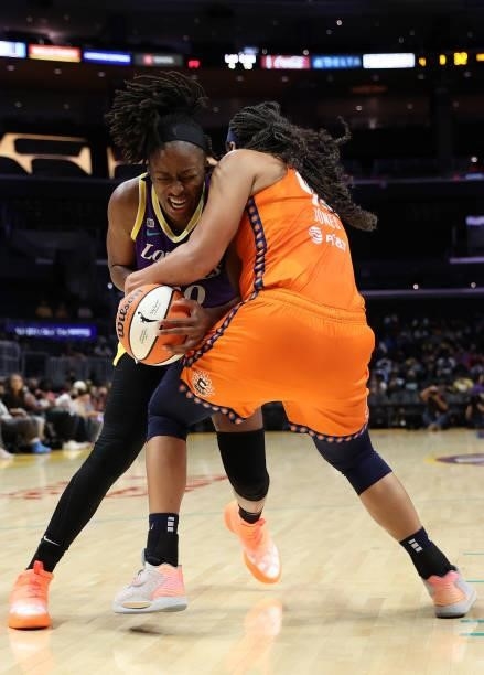 Brionna Jones of the Connecticut Sun ties up the ball with Nneka Ogwumike of the Los Angeles Sparks in the fourth quarter at Staples Center on...