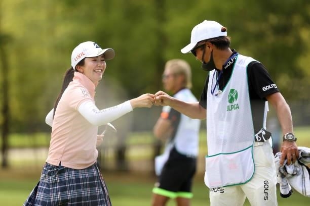 Kotone Hori of Japan fist bumps with her caddie after holing out with the birdie on the 9th green during the second round of the JLPGA Championship...