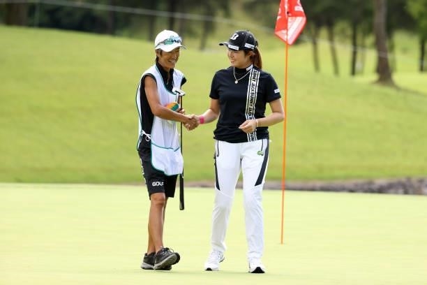 Momoko Osato of Japan shakes hands with her caddie after holing out on the 9th green during the second round of the JLPGA Championship Konica Minolta...