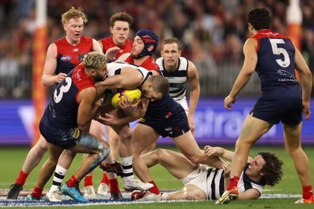 Sam Menegola of the Cats gets tackled by Christian Salem and Angus Brayshaw of the Demons during the AFL First Preliminary Final match between the...