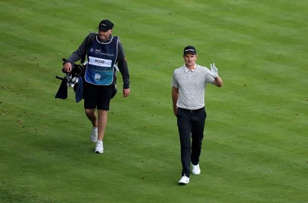 Justin Rose of England walks up the 18th fairway with his caddie/agent Paul McDonnell acknowledging the crowd during Day Two of The BMW PGA...