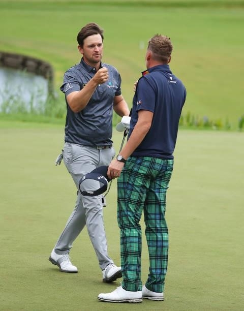 Bernd Wiesberger of Austria fist pumps Ian Poulter of England after their rounds during Day Two of The BMW PGA Championship at Wentworth Golf Club on...