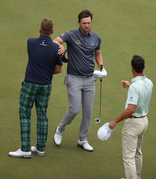 Bernd Wiesberger of Austria congratulates Ian Poulter of England and Billy Horschel of the United States of America after their rounds during Day Two...
