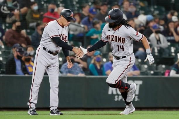 Third base coach Tony Perezchica congratulates Henry Ramos of the Arizona Diamondbacks after his home run against the Seattle Mariners during the...