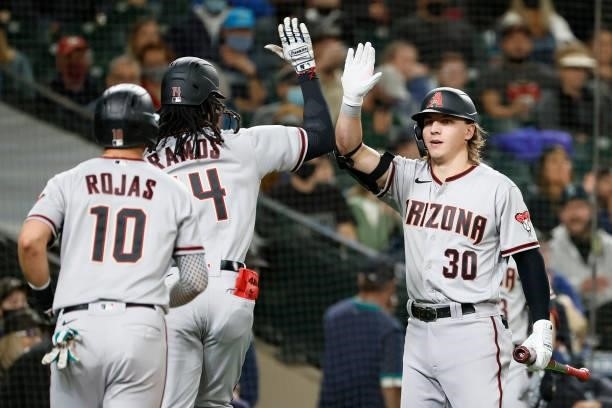 Jake McCarthy congratulates Henry Ramos of the Arizona Diamondbacks after his home run against the Seattle Mariners during the second inning at...