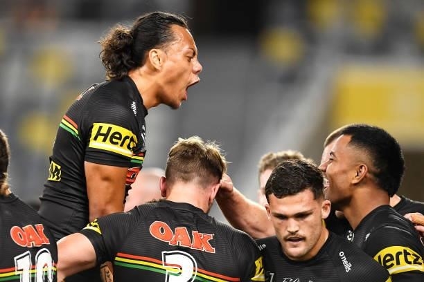 Jerome Luai of the Panthers jumps on his team mates as they celebrate with Stephen Crichton of the Panthers after he scored a try during the NRL...