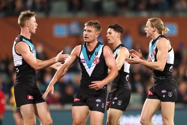 Ollie Wines of the Power is congratulated by team mates after kicking a goal during the AFL Second Preliminary Final match between Port Adelaide...