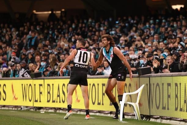 Travis Boak of the Power helps Scott Lycett of the Power off the fence during the AFL Second Preliminary Final match between Port Adelaide Power and...