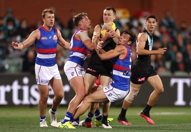Robbie Gray of the Power is tackled by Mitch Hannan and Josh Dunkley of the Bulldogs during the AFL Second Preliminary Final match between Port...