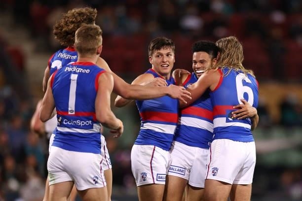Jason Johannisen of the Bulldogs is congratulated by team mates after kicking a goal during the AFL Second Preliminary Final match between Port...