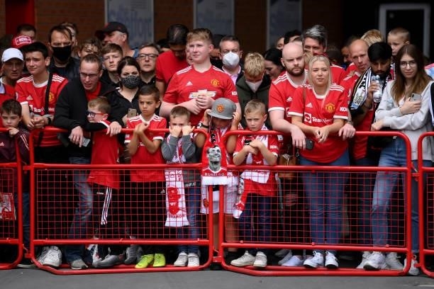 Fans of Manchester United prepare to welcome the players outside the stadium prior to the Premier League match between Manchester United and...