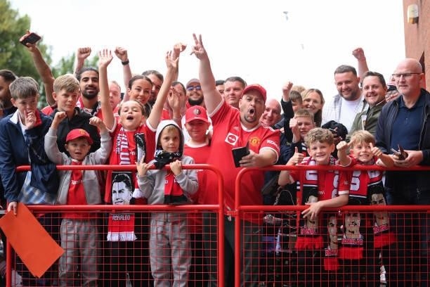 Fans of Manchester United prepare to welcome the players outside the stadium prior to the Premier League match between Manchester United and...