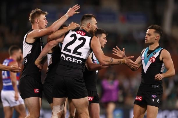 Charlie Dixon of the Power is congratulated by team mates after kicking a goal during the AFL Second Preliminary Final match between Port Adelaide...